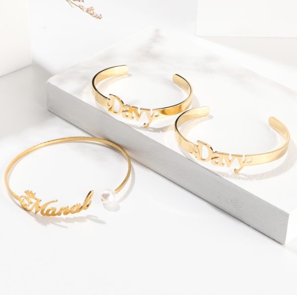 Gold stainless steel custom name bracelets with Davy and Manal lettering, including pearl accent bangle